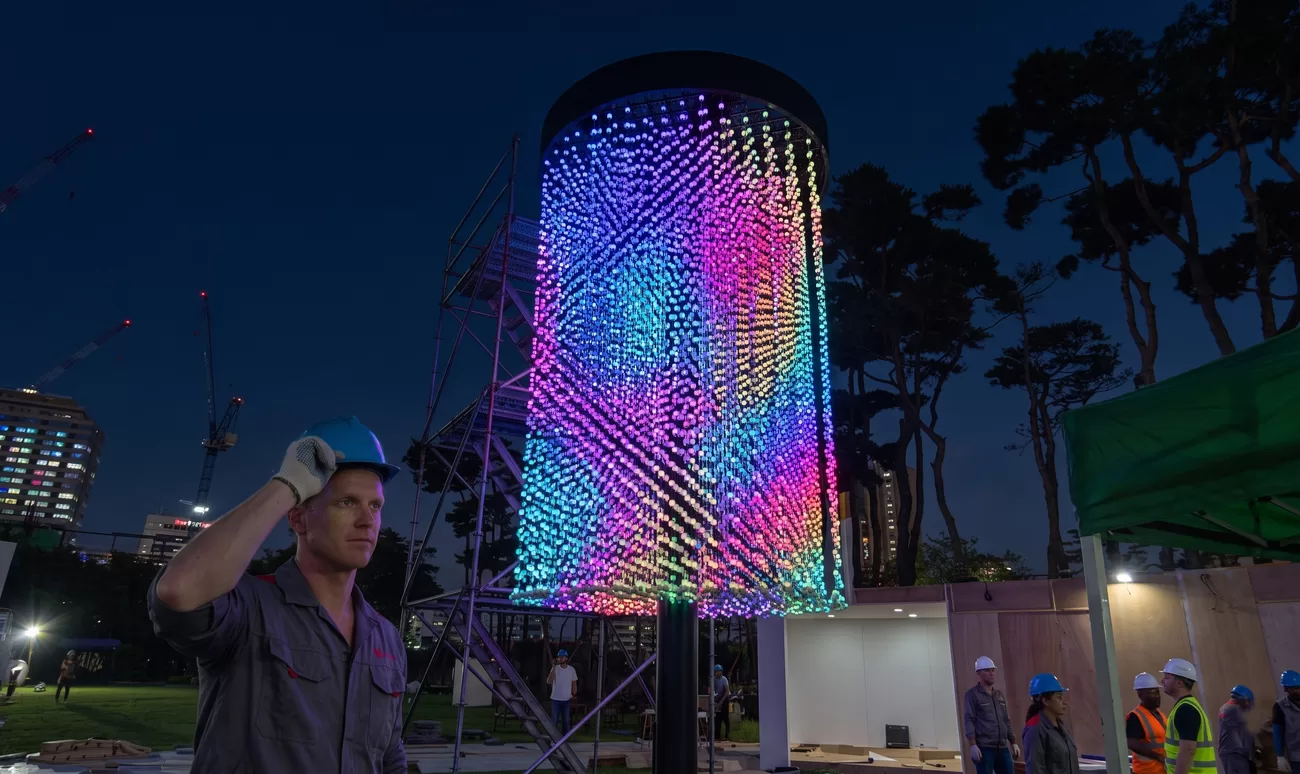 Globe point column lit up on site during installation, photographed from the project record