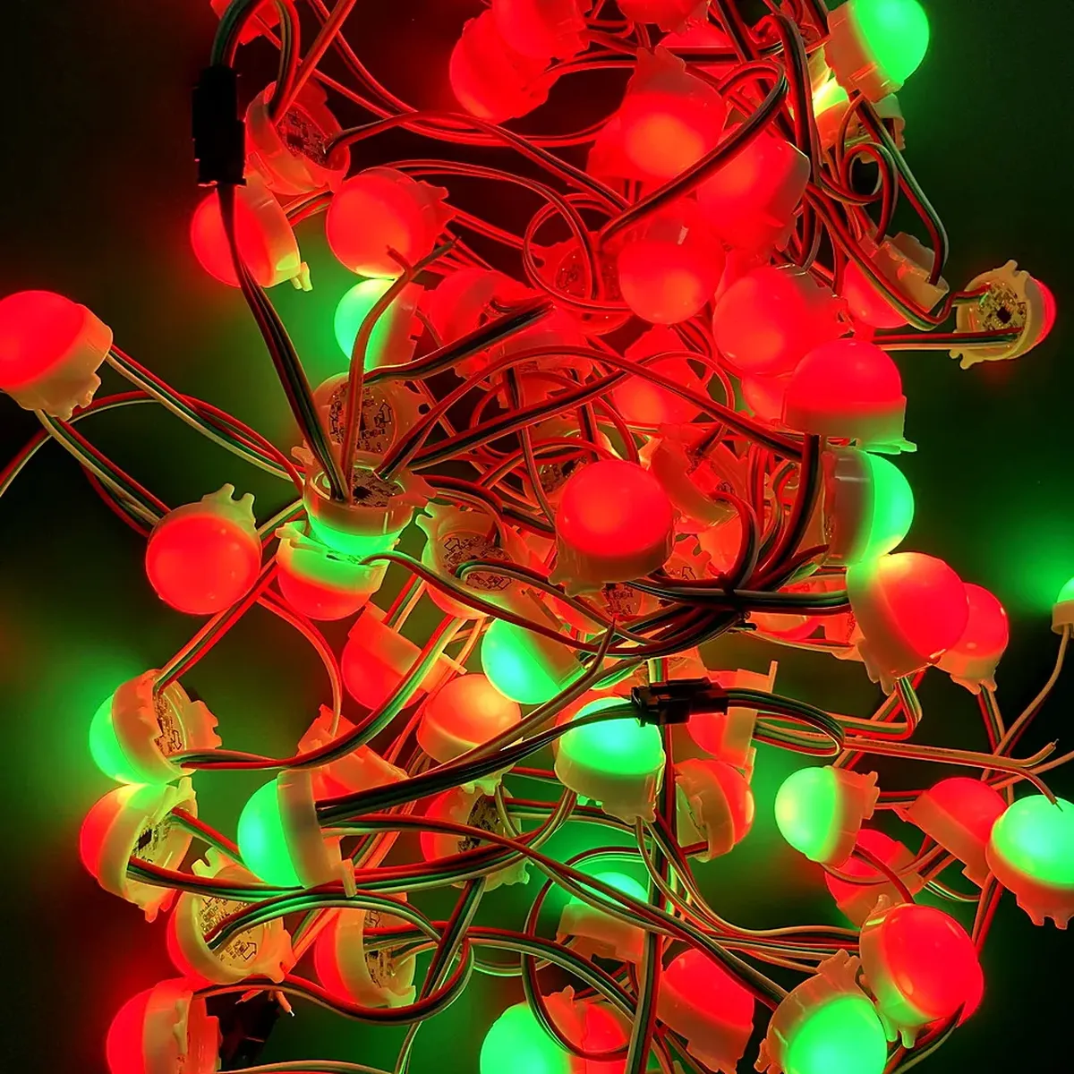 A dense tangle of lit addressable point-light nodes in red and green, the replacement nodes a distributor keeps as spares