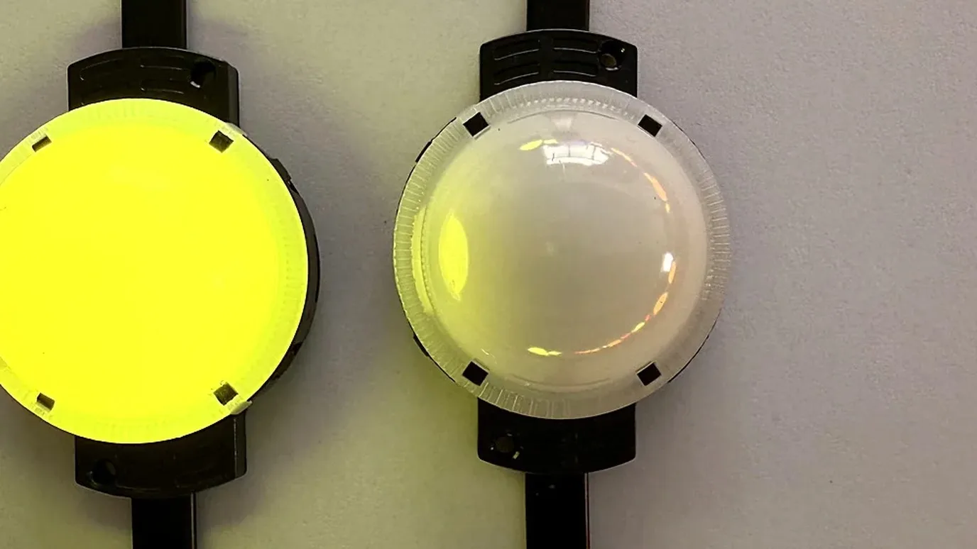 Two addressable LED point light nodes mounted on one cable, the left one lit warm yellow and the right showing its clear lens