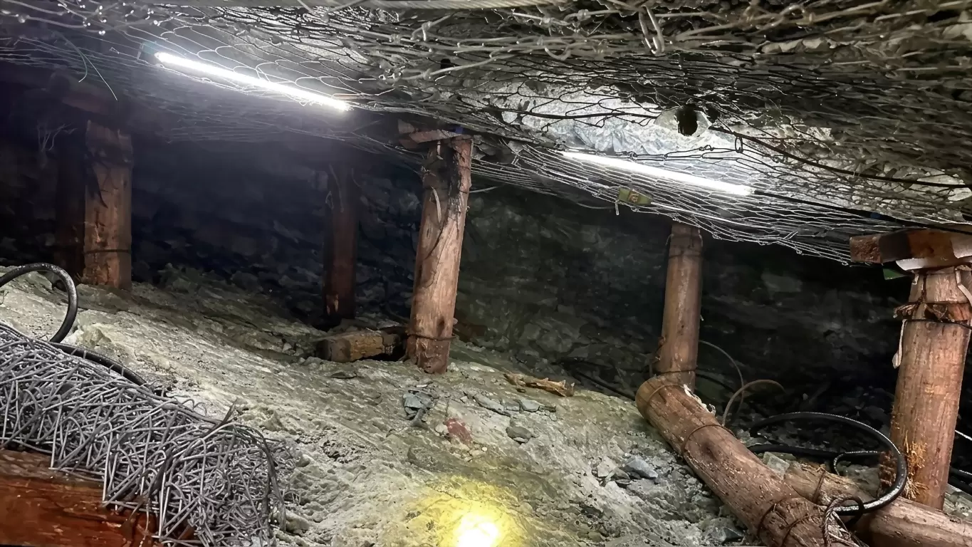 Delivered project: a continuous sealed strip running along the roof of a South African mine tunnel beneath timber props and wire mesh